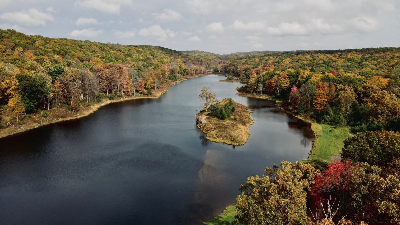 A wooded lake in the Pennsylvania highlands surrounded by autumn colour