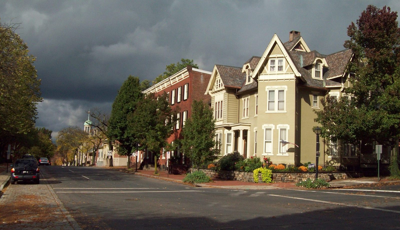 A street of Victorian houses in the Central Bethlehem Historic District under a dark sky
