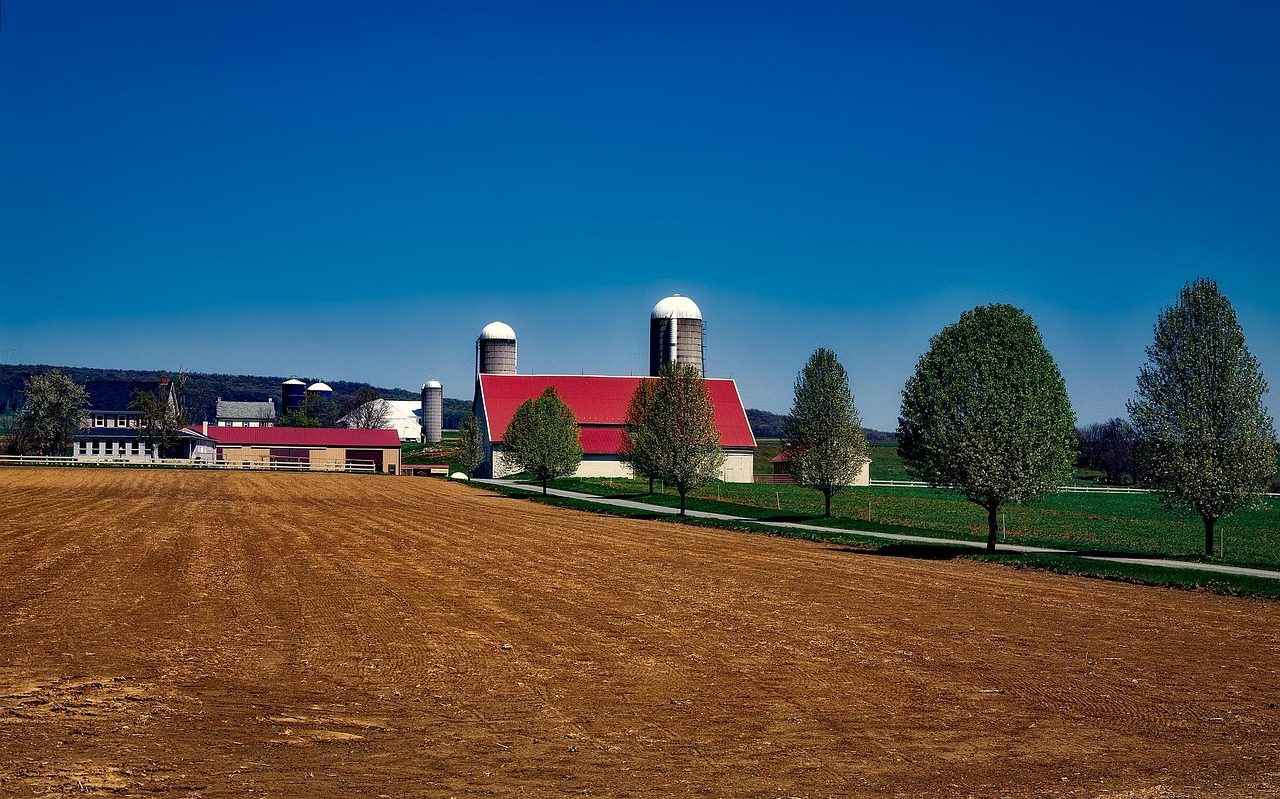 A Lancaster County farm with a red-roofed barn and twin silos above a ploughed field